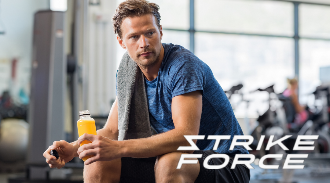 Man with energy drink sitting on work out bench.